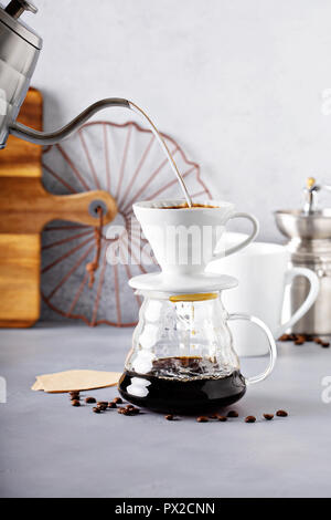 Versare il caffè è realizzato con un bollitore e la caraffa di vetro con acqua calda che viene versato Foto Stock