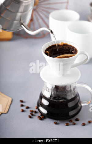 Versare il caffè è realizzato con un bollitore e la caraffa di vetro con acqua calda che viene versato Foto Stock