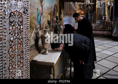 Gli studenti del Patriarcato Armeno Seminario kissing parete esterna dell'archivio di sepoltura dell apostolo san Giacomo il Maggiore all'interno della Cattedrale di Saint James del XII secolo la chiesa armena e la principale chiesa del Patriarcato Armeno di Gerusalemme nel quartiere armeno la città vecchia di Gerusalemme Est Israele Foto Stock