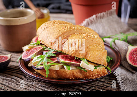 Croissant fresco sandwich con formaggio brie rucola e figg. Una deliziosa prima colazione. Il cibo gustoso. Foto Stock