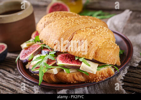 Croissant fresco sandwich con formaggio brie rucola e figg. Una deliziosa prima colazione. Il cibo gustoso. Foto Stock