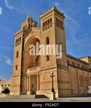 Cicogna bianca, Ciconia ciconia, migrazione oltre le isole maltesi. Grosso uccello il bilanciamento in appoggio sulla sommità di un alto chiesa cattolica torre campanaria, Birzebugga. Foto Stock