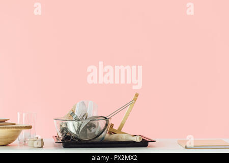 Varie sudicie utensili di cottura sul tavolo isolato in rosa Foto Stock