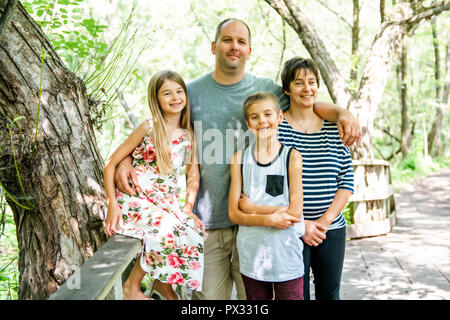 Famiglia avente una buona volta in foresta con bambino Foto Stock