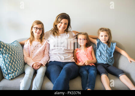 La madre e le figlie sul divano di casa Foto Stock