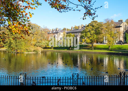 Il lago nel Pavilion Gardens park con ampia a piedi al di là, Buxton, Derbyshire, Regno Unito Foto Stock