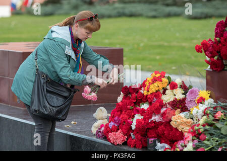 Mosca, Russia. 17 ottobre, 2018. Una donna getta fiori all'Eroe della seconda guerra mondiale città Memoriale per la città di Kerch nel centro di Mosca il 18 ottobre 2018, un giorno dopo un 18-anno-vecchio studente ha aperto il fuoco sui suoi colleghi studenti, lasciando almeno 21 morti e decine di feriti in Crimea technical college di Kerch Crimea. Credito: Victor Vytolskiy/Alamy Live News Foto Stock