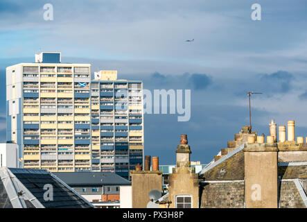 Leith, Edimburgo, Scozia, Regno Unito, 19 ottobre 2018. Regno Unito: Meteo sole illumina gli edifici e i tetti in Leith, compresi Couper Street a torre, alloggi sociali appartamenti dove un residente visualizza un St Andrews cross si intraversa bandiera su un balcone Foto Stock