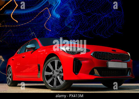 Auto rossa su uno sfondo nero. Elegante e moderna, luminosa immagine della vettura per la progettazione di soluzioni. Foto Stock