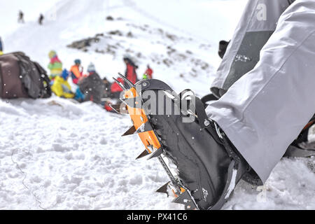 Preparazione per una passeggiata sul ghiacciaio. Scarpone da trekking e alpinismo gatti. Foto Stock