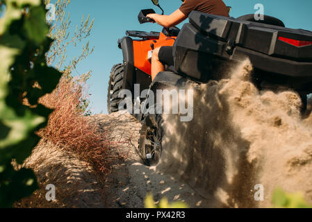 Atv rider salire la montagna di sabbia, vista posteriore Foto Stock