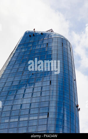 Operatori di manutenzione o detergenti per finestre lavorando da corde in al di fuori di un blocco a torre di Londra, Regno Unito Foto Stock