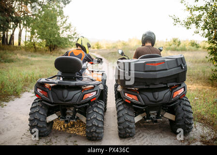 Due piloti atv in caschi, vista posteriore, moto quad Foto Stock