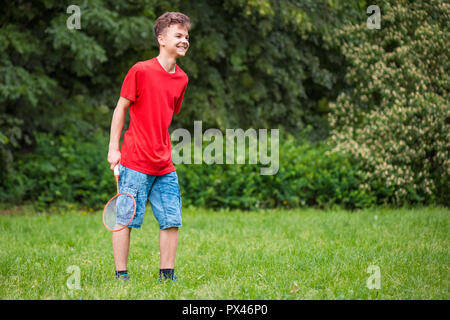 Teen boy playing badminton in posizione di parcheggio Foto Stock