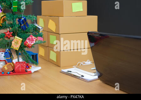 Parcel scatola di cartone al titolare di azienda sul luogo di lavoro durante il periodo natalizio. Vendita online, e-commerce concept Foto Stock