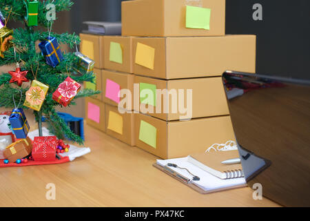 Parcel scatola di cartone al titolare di azienda sul luogo di lavoro durante il periodo natalizio. Vendita online, e-commerce concept Foto Stock