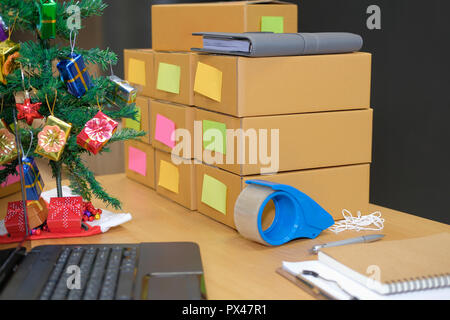 Parcel scatola di cartone al titolare di azienda sul luogo di lavoro durante il periodo natalizio. Vendita online, e-commerce concept Foto Stock