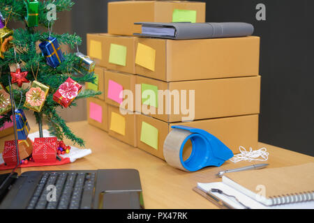 Parcel scatola di cartone al titolare di azienda sul luogo di lavoro durante il periodo natalizio. Vendita online, e-commerce concept Foto Stock