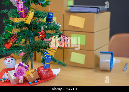 Parcel scatola di cartone al titolare di azienda sul luogo di lavoro durante il periodo natalizio. Vendita online, e-commerce concept Foto Stock