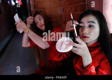 Il vietnamita ragazze con i tradizionali abiti lunghi Ao Dai fare il trucco. Ho Chi Minh City. Il Vietnam. Foto Stock