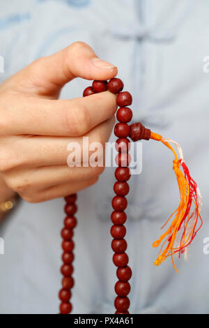 Una donna orante Mala perle, la preghiera buddista perle. Close-up. Ho Chi Minh City. Il Vietnam. Foto Stock