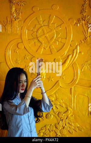 Thien appeso tempio buddista. Pregando donna con bastoncini di incenso in mani. Ho Chi Minh City. Il Vietnam. Foto Stock