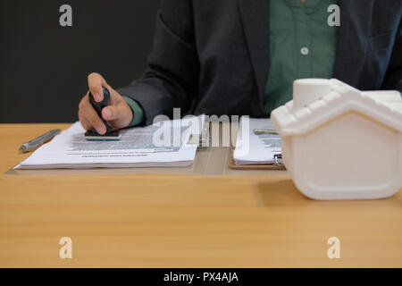 Real estate agent utilizzando stamper per la stampigliatura approvato il mutuo ipotecario contratto documento Foto Stock