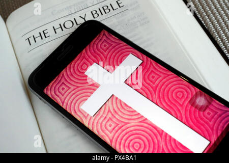 Carta bibbia e la Bibbia digitale app sullo smartphone. Foto Stock