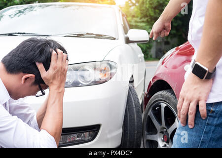 Due uomini sostenendo dopo un incidente di auto Traffic Collision sulla strada Foto Stock