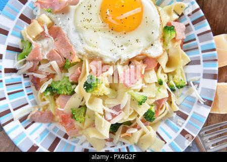 Tagliatelle con broccoli, prosciutto e uova fritte Foto Stock