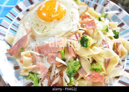Tagliatelle con broccoli, prosciutto e uova fritte Foto Stock