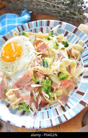 Tagliatelle con broccoli, prosciutto e uova fritte Foto Stock