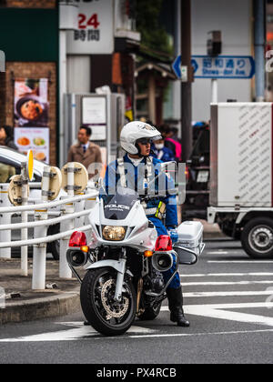 Tokyo Giappone polizia motociclista attende in corrispondenza di una giunzione a Tokyo Foto Stock