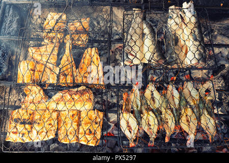 Pesce fresco alla griglia: gamberi e pesce, polpo, ostriche cibo sfondo / Barbecue per la cottura barbecue di pesce sul fuoco / Indonesia Foto Stock