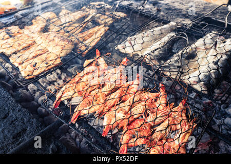 Pesce fresco alla griglia: gamberi e pesce, polpo, ostriche cibo sfondo / Barbecue per la cottura barbecue di pesce sul fuoco / Indonesia Foto Stock