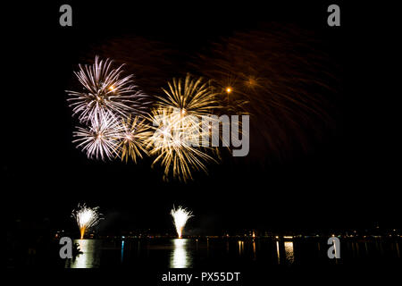 Esplosioni di fuochi d'artificio Razzi nella notte su acqua Foto Stock
