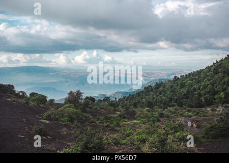 I turisti escursione thehanging paesaggi intorno a Volcan Pacaya, uno del Guatemala la maggior parte dei vulcani attivi, dalla roccia vulcanica nera a lussureggianti foreste Foto Stock