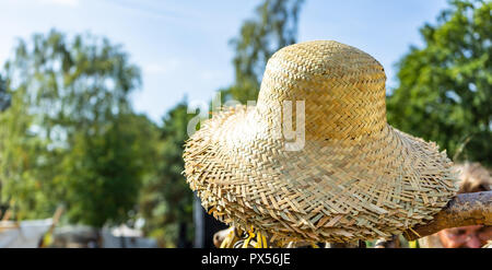 Cappelli di paglia nella luce del sole in un heap in vendita. Foto Stock