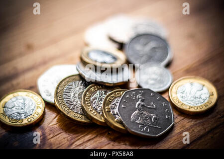 Nuovo grande sterlina GBP monete posa casualmente sulla superficie di legno. Ricchezza, denaro contante, modificare. Foto Stock