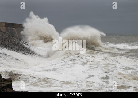 Tempesta di onde che si infrangono contro Porthcawl frangionde Foto Stock