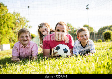 La famiglia felice lifestyle giocare a calcio al di fuori Foto Stock