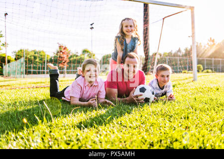 La famiglia felice lifestyle giocare a calcio al di fuori Foto Stock