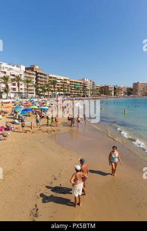 Sole spagnolo spiaggia Torrevieja in ottobre con le persone che si godono la sabbia di mare e meteo Foto Stock