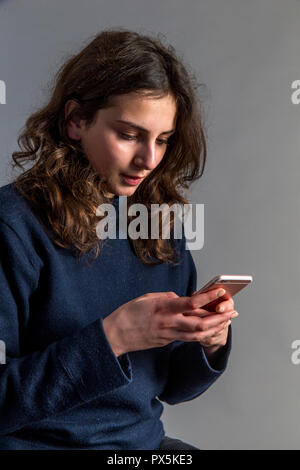 Giovane donna utilizzando un telefono cellulare. Parigi, Francia. Foto Stock