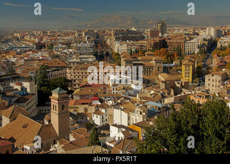 Vista aerea sulla periferia di Granada, Andalusia, Spagna, con molti edifici di appartamenti e la catena montuosa della Sierra Nevada in background Foto Stock