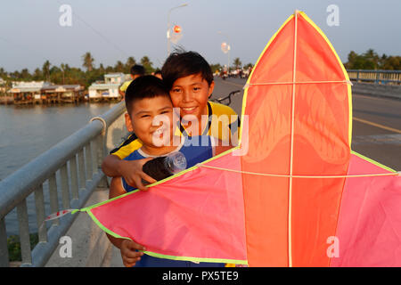 I bambini vietnamiti aquiloni in Cai Be bridge. Il Vietnam. Foto Stock