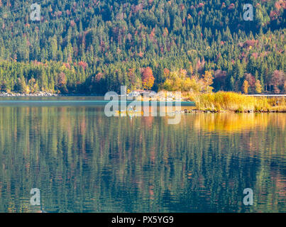 Immagine di kayaker su di una tranquilla montagna lago in autunno Foto Stock