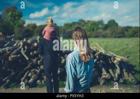 Un multi famiglia generazionale sta esaminando alcuni log nella foresta Foto Stock