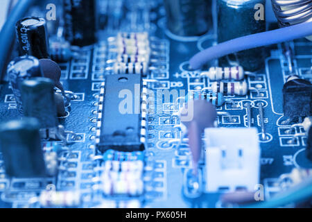 Microchip, condensatori, resistenze su blue scheda computer close-up. Background Industriale. Foto Stock