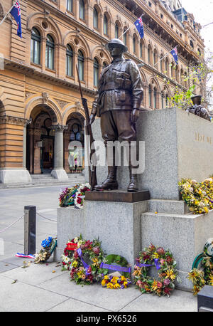 Ghirlande poste alla base della statua di bronzo di un soldato di commemorazione Anzac Day in Martin Place Sydney NSW Australia. Foto Stock